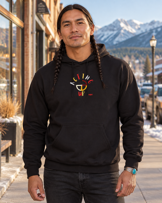 AI-generated lifestyle mockup of the black Acting Up hoodie on a braided male model in Montana.